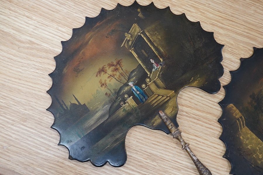 A pair of 19th century papier mache face screens or fans, hand painted with figures, 39cm in length. Condition - one broken and repaired